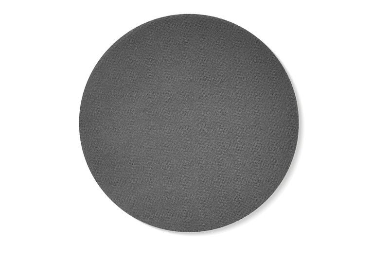 A plain, dark gray, textured circular mat or surface is centered on a white background, casting a faint shadow to the right.