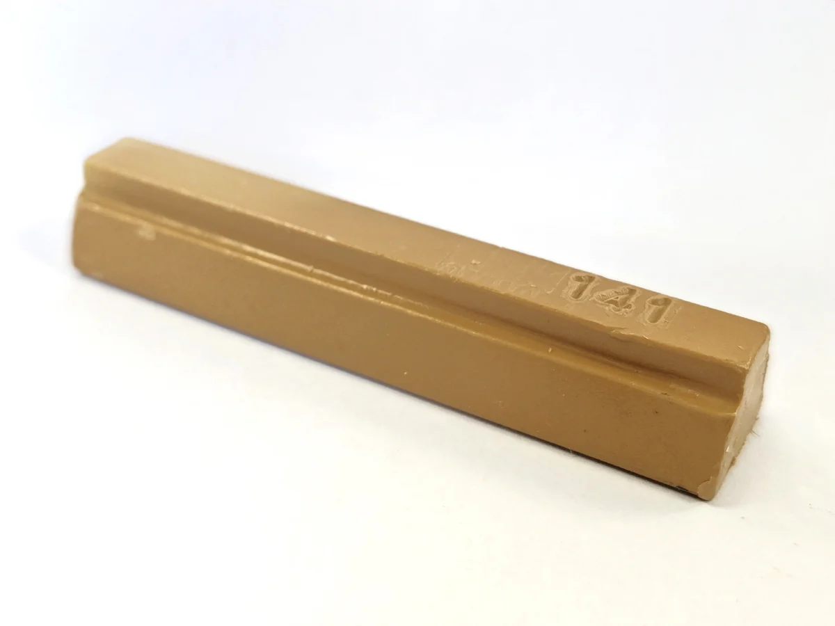 A Konig 8cm Hard Wax Filler Stick 142 Medium Oak, tan and rectangular with a top groove, rests on a white surface.