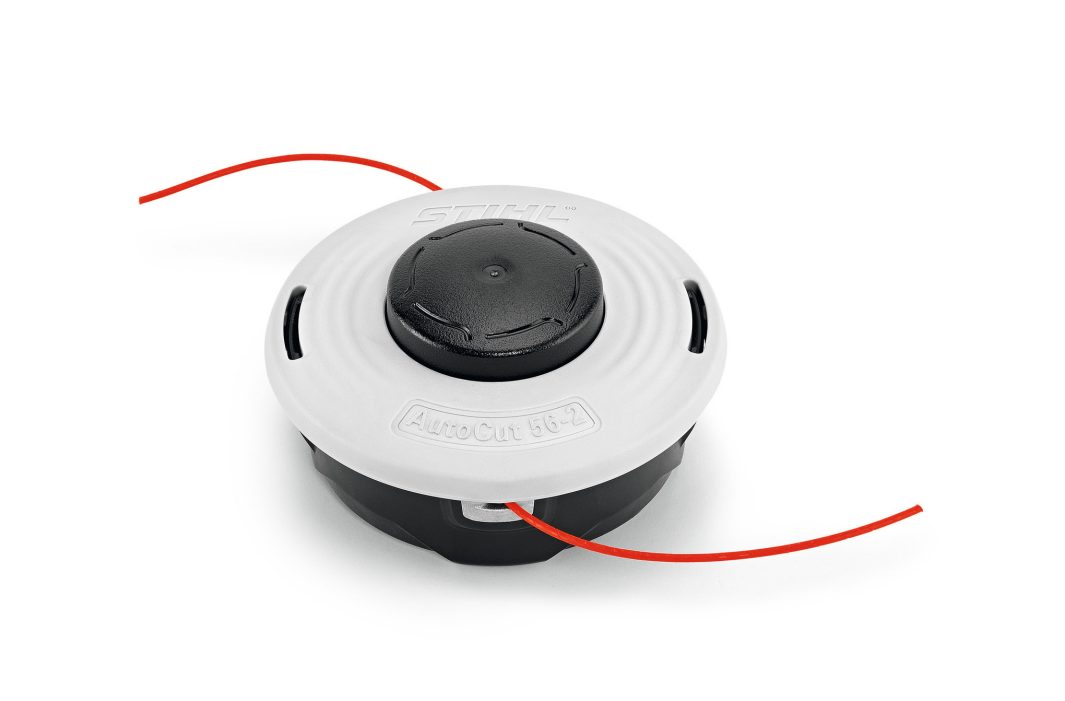 A white and black STIHL trimmer head with two red trimmer lines extending from either side, set against a plain white background.