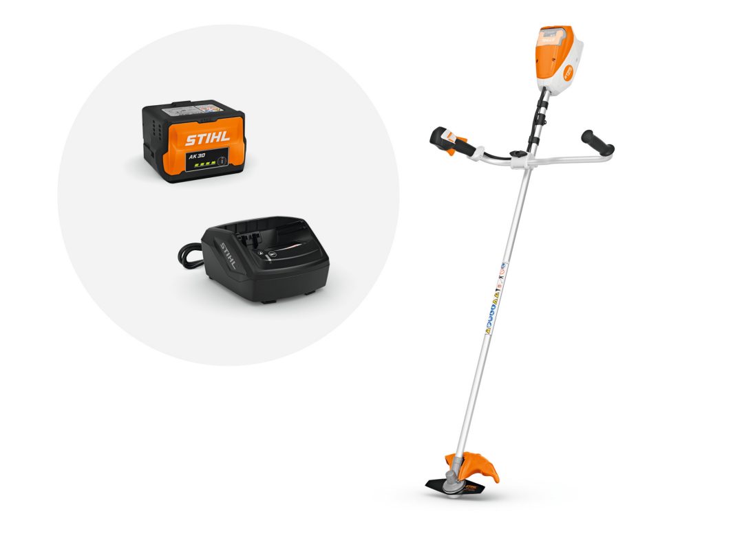 A cordless string trimmer with orange and white accents sits next to a detachable battery and black charging dock on a white background.