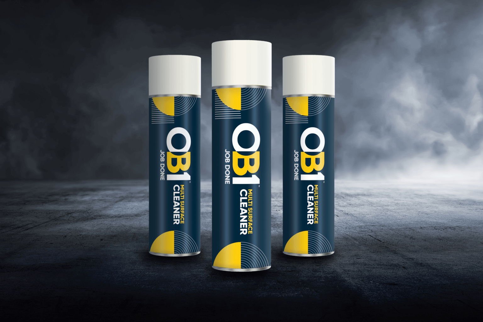 Three upright 500ml cans of OB1 Multi-surface Cleaner with blue, yellow, and white labels on a dark textured surface and smoky background.