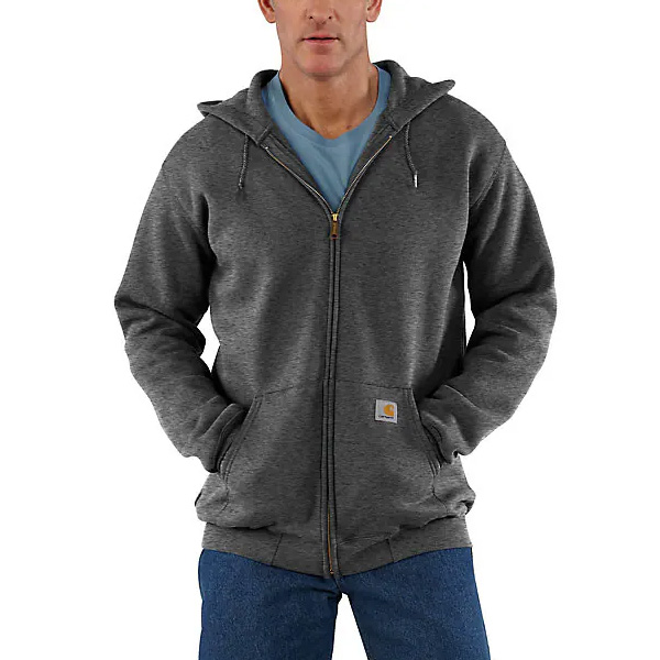 A person in a Carhartt Carbon Heather hoodie (XS), light blue tee, and jeans stands with hands in pockets; logo patch by zipper.