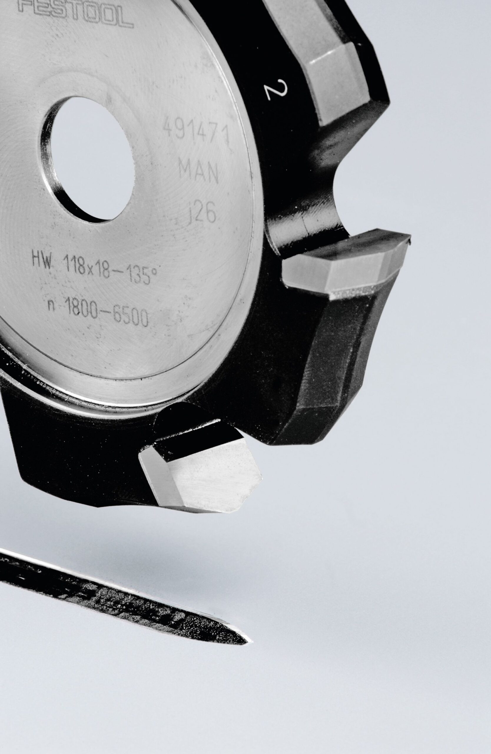 Close-up of the Festool 491471 cutter’s sharp blade and a jigsaw blade on a light gray surface, ideal for aluminum work.
