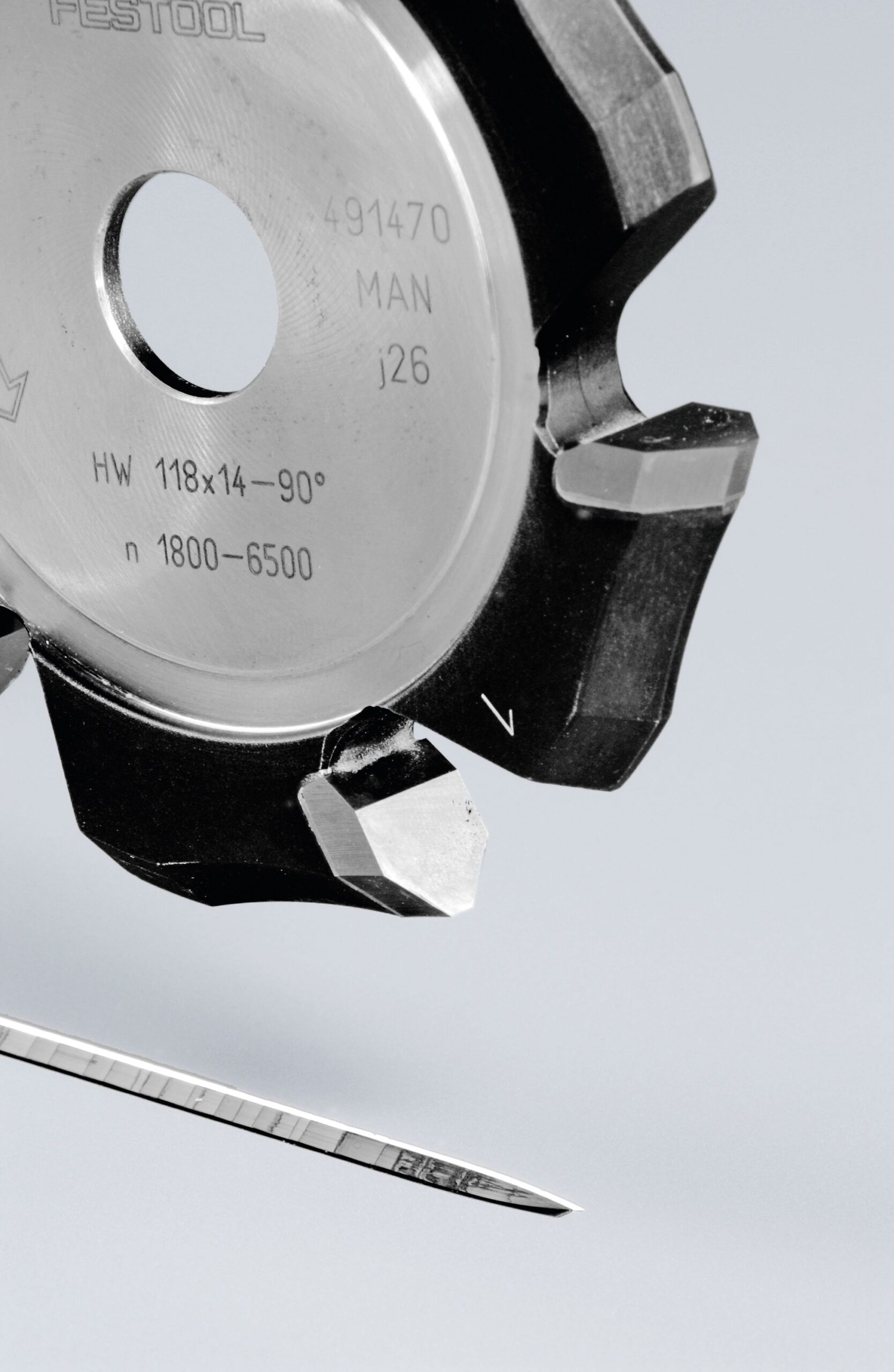 Close-up of a Festool 491470 metal saw blade with sharp teeth and a sewing needle below, on a pale background.