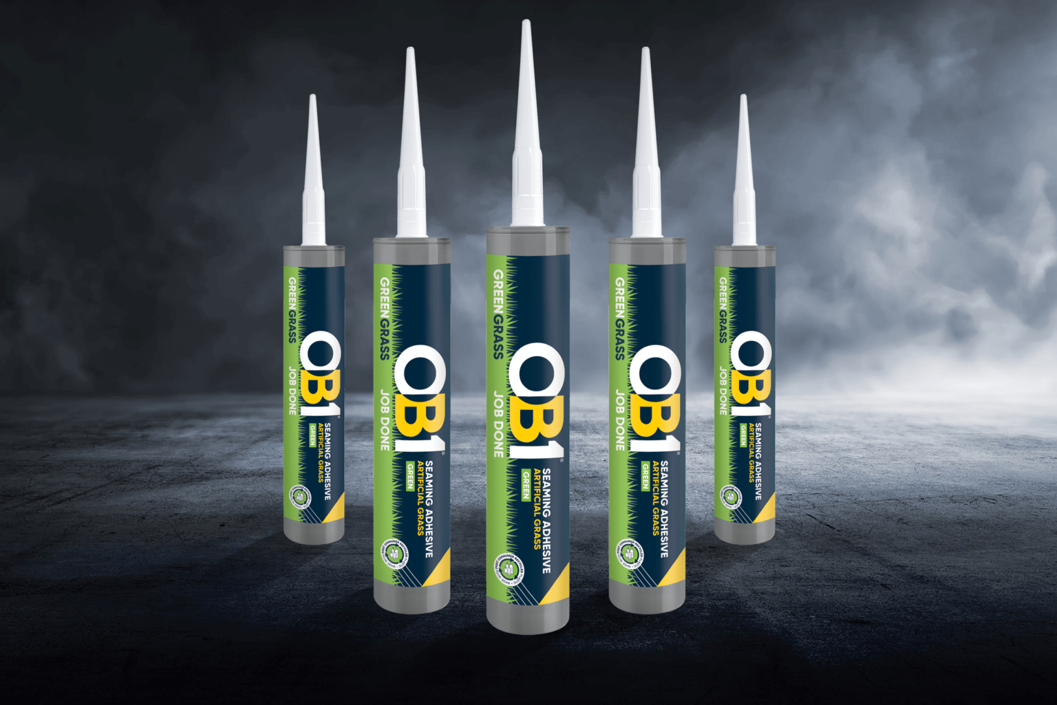 Five OB1 Paint & Varnish Remover 500ml cans in blue, green, and yellow stand upright on a dark surface with a misty backdrop.
