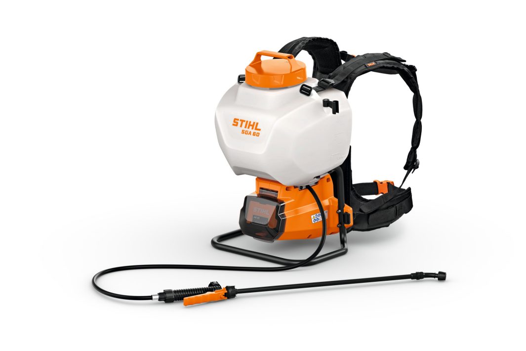 A white and orange STIHL SGA 85 backpack sprayer with padded straps, battery compartment, and black spray lance for garden use.