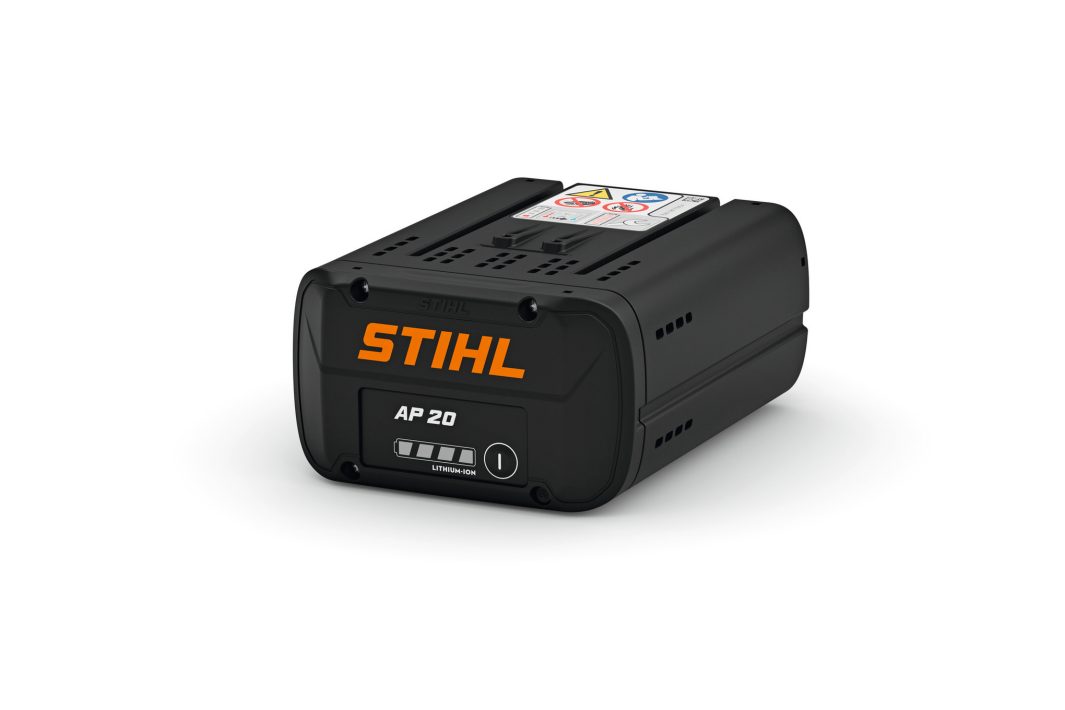 A black STIHL AP 20 lithium-ion battery with orange branding rests on a white background, showing its power indicator and safety label on top.