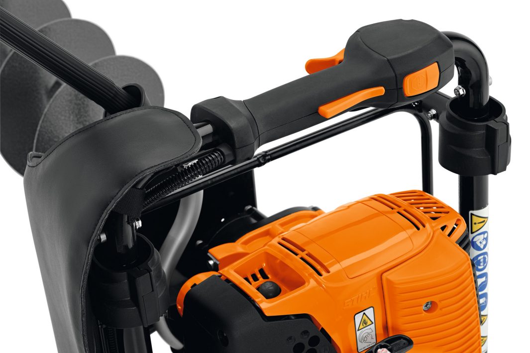 Close-up of the Stihl BT 131 Earth Auger, displaying its handle, control buttons, engine housing, and safety stickers; used for drilling earth.