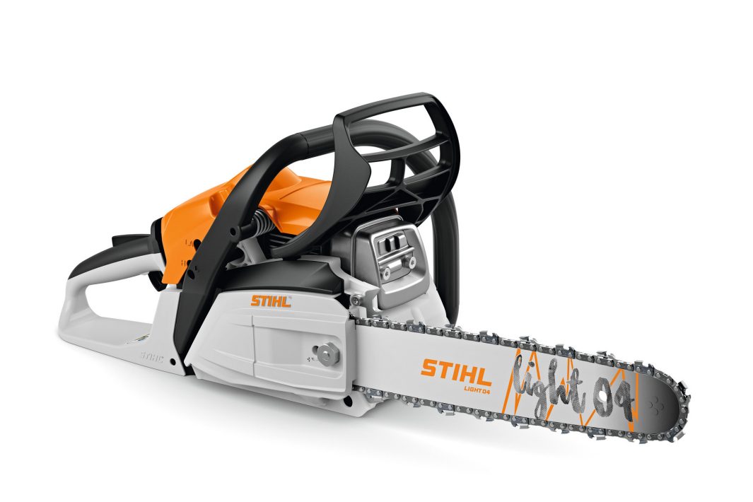 A Stihl chainsaw with an orange and grey body lies on its side, featuring a protective hand guard and visible chain detailing.