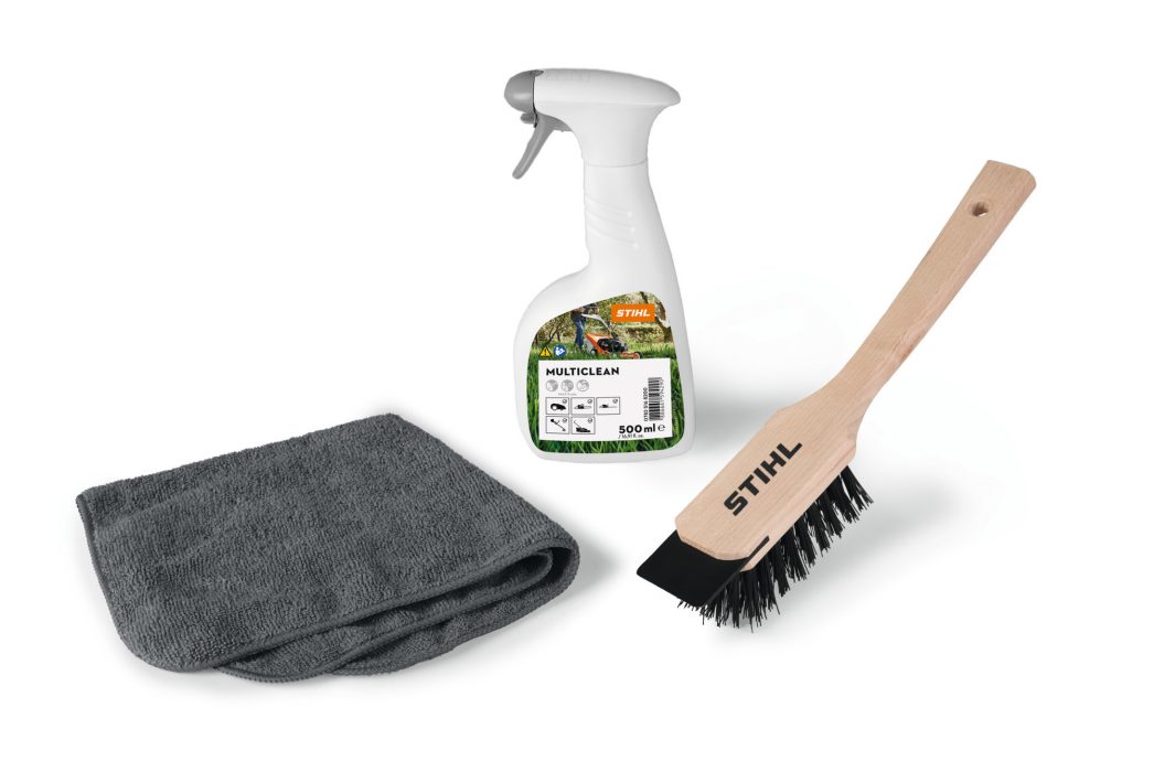 A cleaning set with a grey microfibre cloth, STIHL Multiclean spray bottle, and wood-handled brush with black bristles on white.