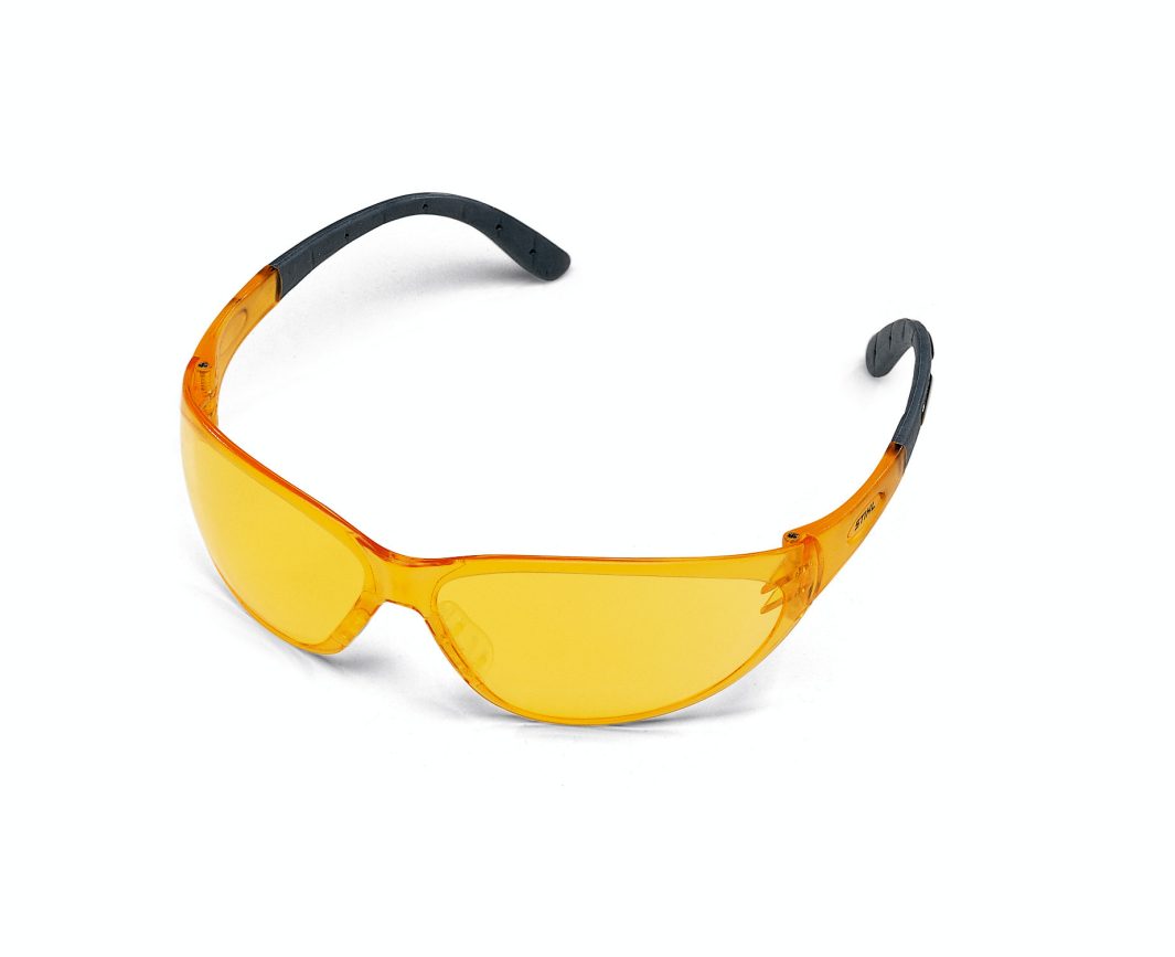 A pair of safety glasses with orange-tinted lenses and black, curved arms rests on a plain white background.