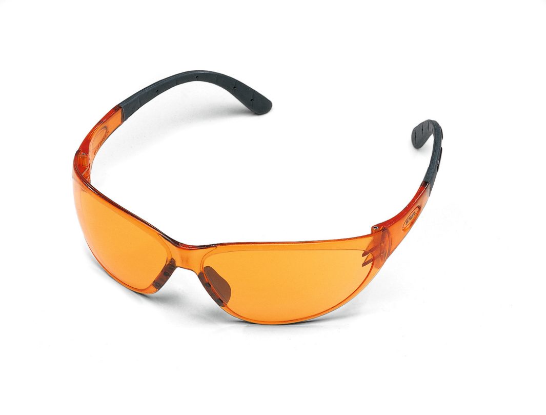 Orange-tinted safety glasses with black arms rest on a white background. Their wraparound design looks lightweight and ergonomic.