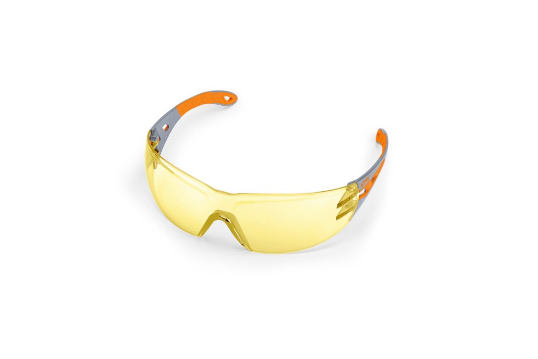 Yellow-tinted safety glasses with a wraparound design and orange and grey arms, displayed on a plain white background.