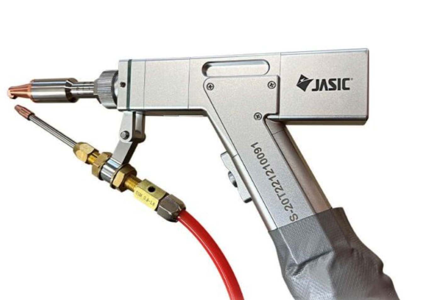 A close-up of a silver JASIC welding torch with a red hose attached, displaying various metal fittings and details against a white background.