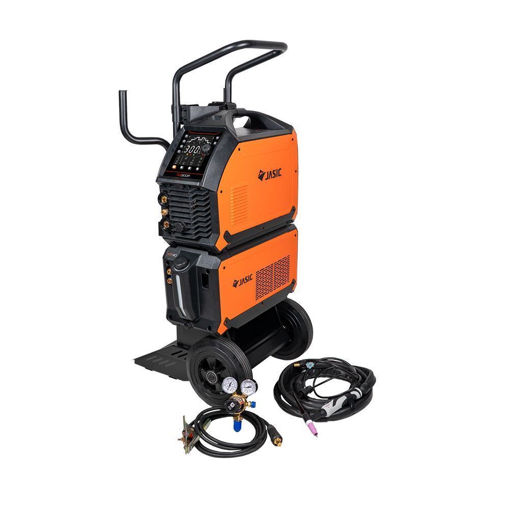An orange and black Jasic welding machine on wheels with a control panel, handles, and attached cables; additional cables and a gauge are placed on the ground nearby.