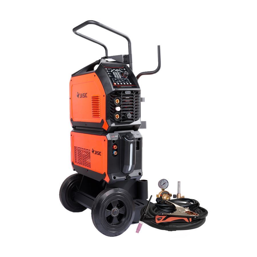 Orange and black industrial welding machine on a wheeled trolley, featuring a control panel and cables. Additional welding accessories such as hoses and gauges are arranged beside the trolley, all set against a white background.