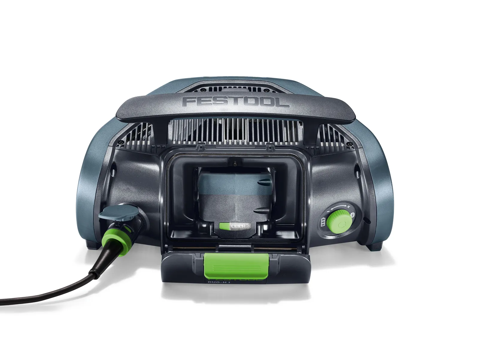 A Festool battery charger with a power lead plugged in, featuring a central battery slot, green adjustment knob, and grey and green design elements.