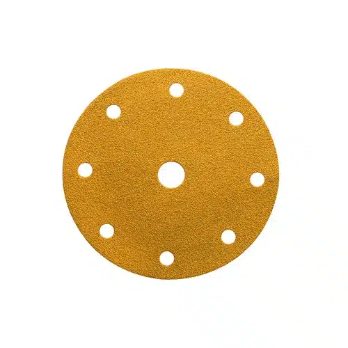 A round yellow sandpaper disc, such as the Mirka Gold 150mm Grip 7 Holes (100PC), features one centre hole and seven smaller holes evenly spaced near the edge, designed for efficient dust extraction when used with orbital sanders.