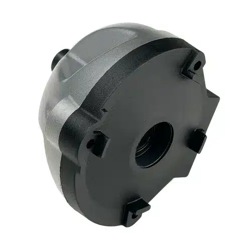 Black plastic circular mechanical part with a central hole and three protruding tabs, shown against a white background. The textured surface and precise shape indicate its functionality as part of the Mirka Carbon Brush+Cap Kit No. 76+78 for Miro 955/955-S, designed for enclosing or mounting components in this machinery.