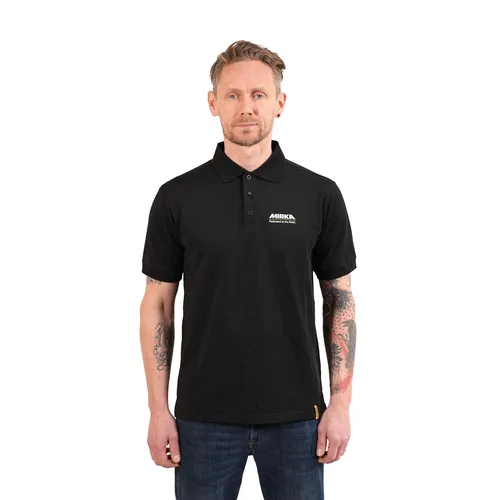 A man with tattoos on both arms wears a black short-sleeve polo shirt and blue jeans, standing against a plain white background, facing forwards with a neutral expression.