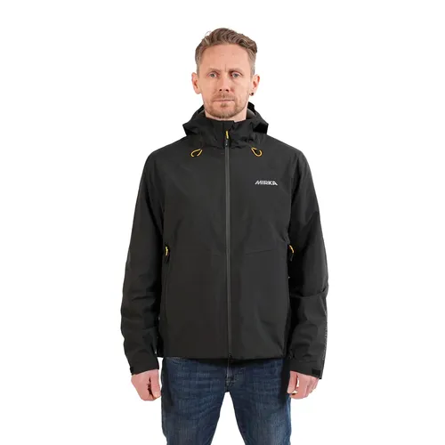 A man wearing a black shell jacket with yellow accents and blue jeans stands facing forwards against a plain white background.