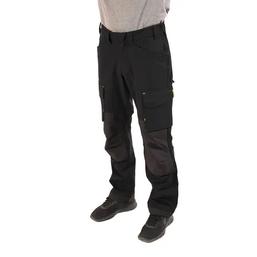 A person wearing black Mirka® Work Trousers and black shoes stands facing forwards, with a grey shirt partially visible. The image shows the trousers from waist to feet.