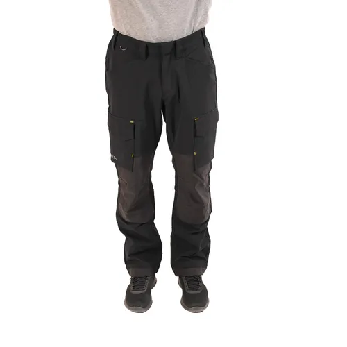 A person wearing black Mirka® Work Trousers and grey shoes stands facing forwards against a white background, with their upper body mostly out of frame.