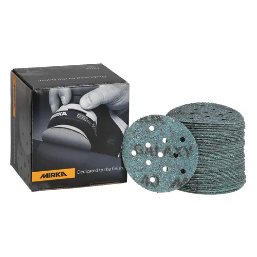 A box of Mirka Galaxy 77mm Multifit Grip Sanding Discs (50pcs) is shown next to a large stack of round, teal-coloured abrasive discs with multiple holes. The box displays an image of a person using a sander. These sanding discs feature the innovative Multifit Grip design and belong to the Mirka Galaxy range, known for efficient and high-quality sanding performance.