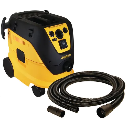 A yellow and black Mirka vacuum cleaner with control buttons on top, accompanied by a coiled flexible hose and two attachments placed in front.