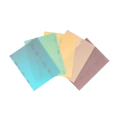 Five coloured translucent sheets—blue, green, yellow, beige, and purple—in the 130x170mm size are fanned out against a white background. These are Mirka Novastar Flex 130x170mm Grip Sanding Sheets (25pc), engineered for flexibility and premium sanding performance.